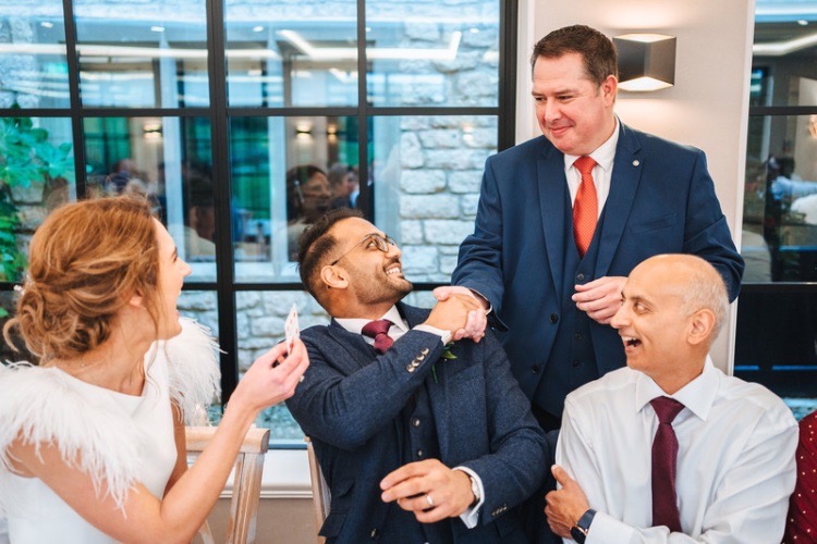 Gloucestershire Magician Richard Parsons shaking a smiling Groom's hand as he prepares to leave their wedding